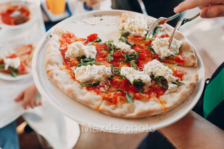 The waiter serves pizza on a dish example image 1