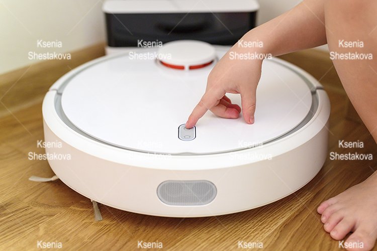 kids hand press button to turn the robot vacuum cleaner on example image 1