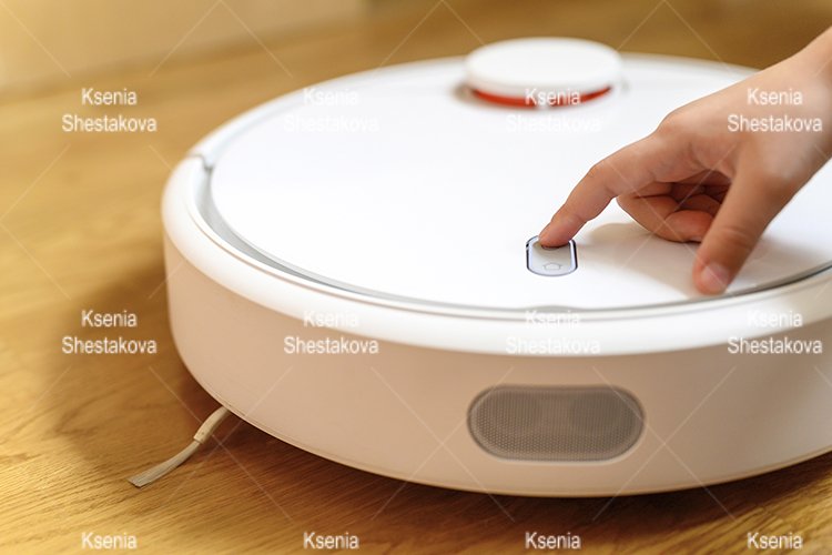 kids hand press button to turn the robot vacuum cleaner on example image 1