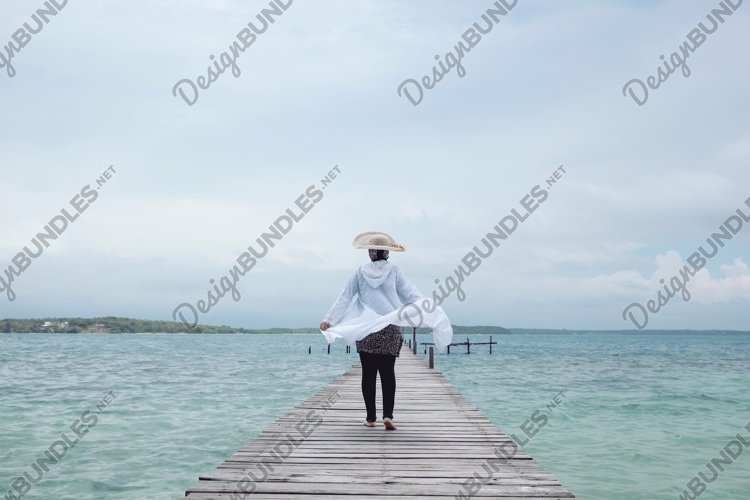 Woman walking on wooden dock example image 1