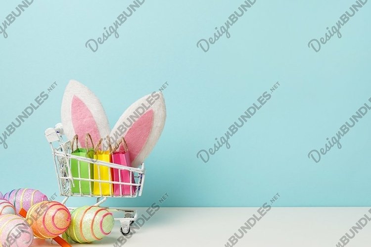 Colorful painted Easter egg with shopping cart, bunny ears