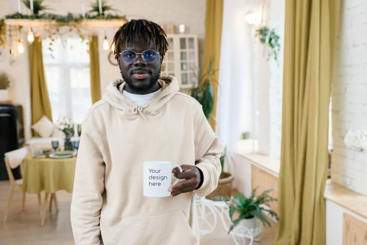 A white mug in the hands of a man in a home interior.