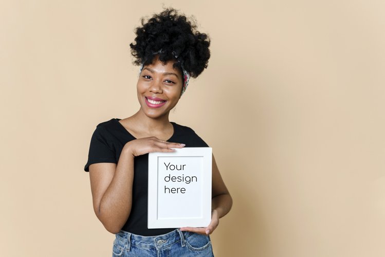 Black woman holding vertical blank frame with mockup