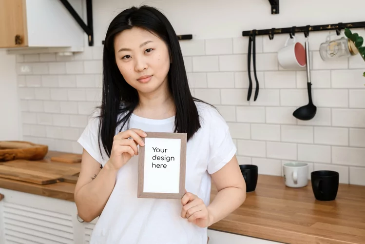 Asian female model holding white vertical frame mockup