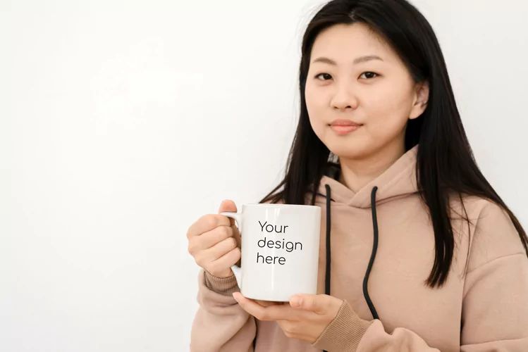 Asian woman holding a white mug. Mockup for design