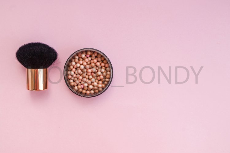 Cosmetic blush in spheres on a pink background.