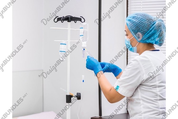 Doctor prepares the system with a dropper and a solution example image 1