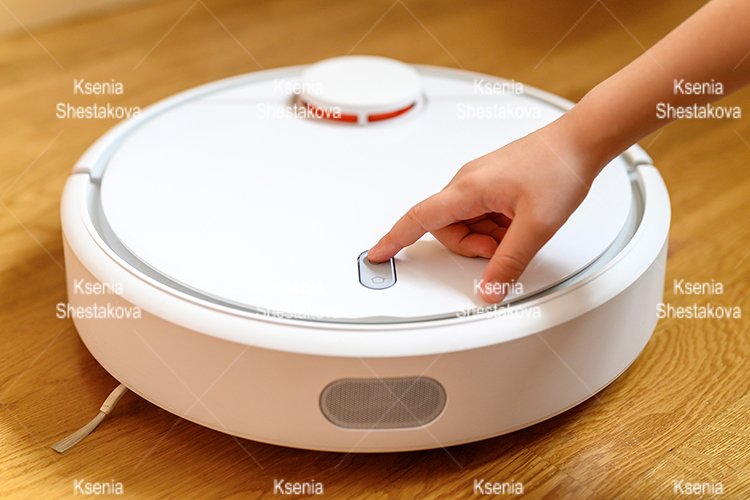 kids hand press button to turn the robot vacuum cleaner on example image 1