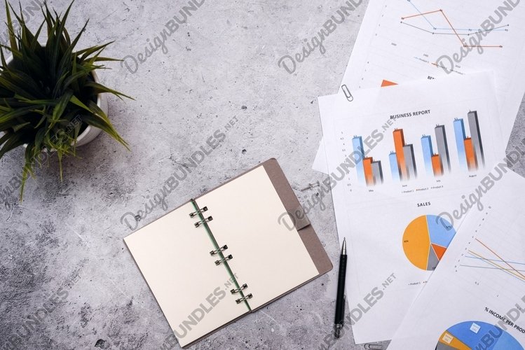 Notepad with a blank white sheet is on the graph. Business example image 1