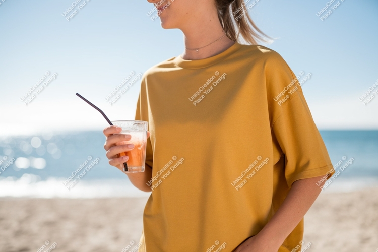 Woman holding orange drink on beach ocean summer