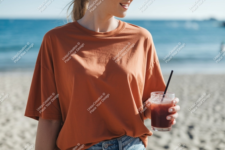 Orange shirt woman holding drink beach image