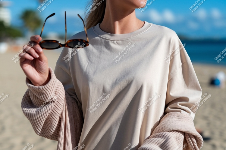 Woman holding sunglasses at beach sand