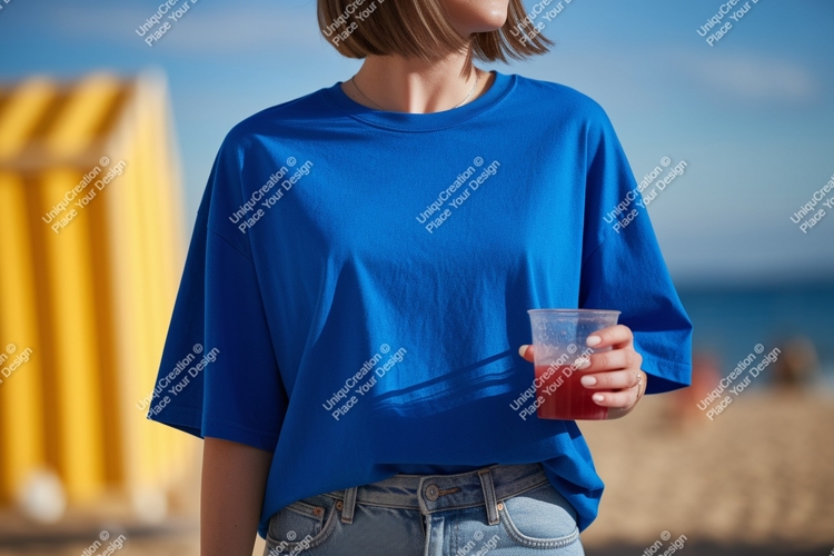Blue shirt person holding drink beach image