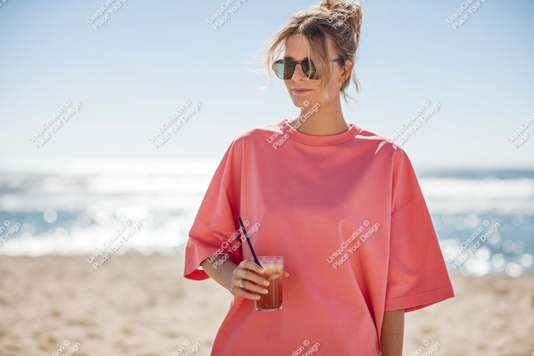 Woman wearing pink shirt holding drink sunglasses