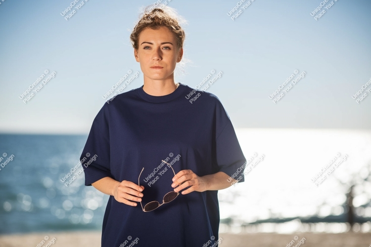 Woman dark blue shirt holding sunglasses beach image
