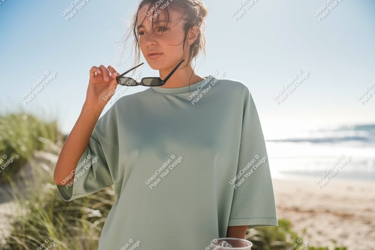 Woman holding sunglasses at beach ocean
