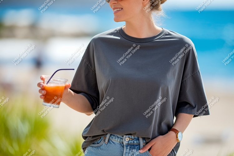Woman wearing grey t shirt holding orange drink image