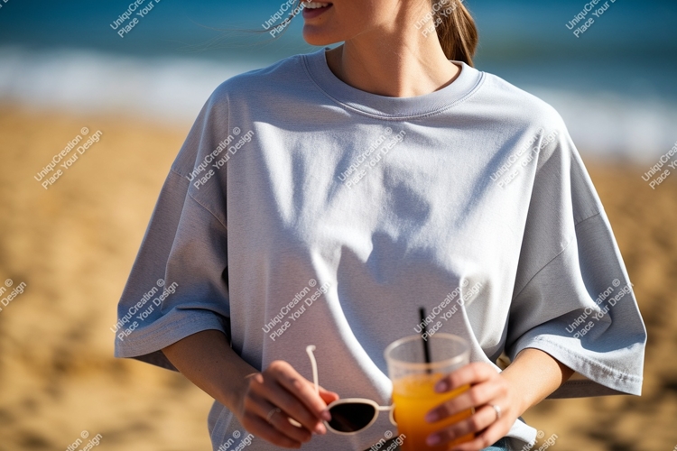 Woman wearing light blue t shirt holding sunglasses and drin