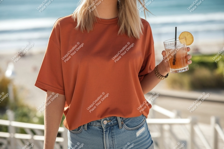 Woman wearing orange shirt holding drink beach
