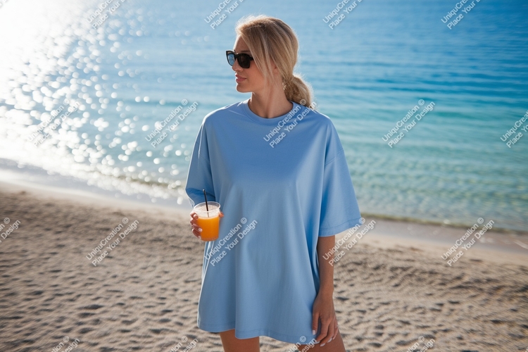 Woman wearing blue t shirt holding orange drink on beach