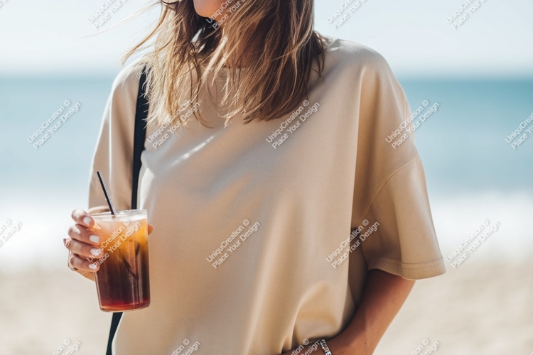 Woman holding iced drink on beach ocean sand