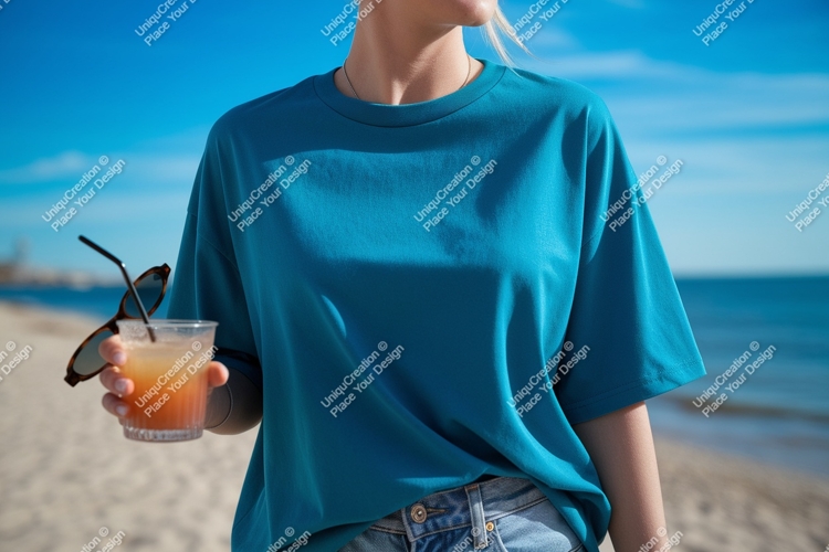 Teal shirt holding drink sunglasses beach