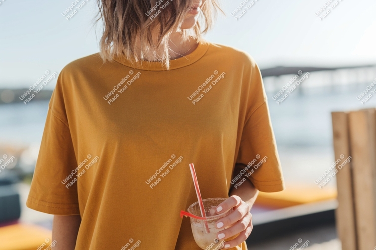 Woman wearing mustard yellow t shirt holding drink