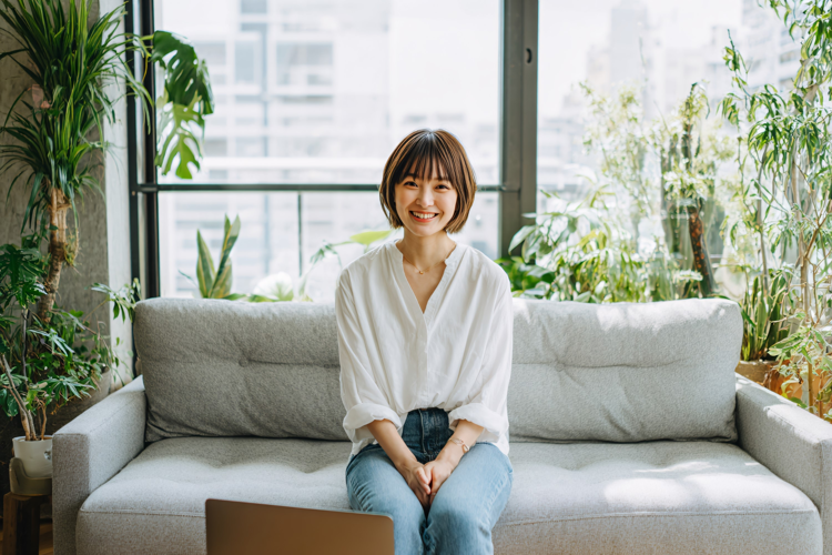 Young Woman Relaxing with Laptop on Sofa