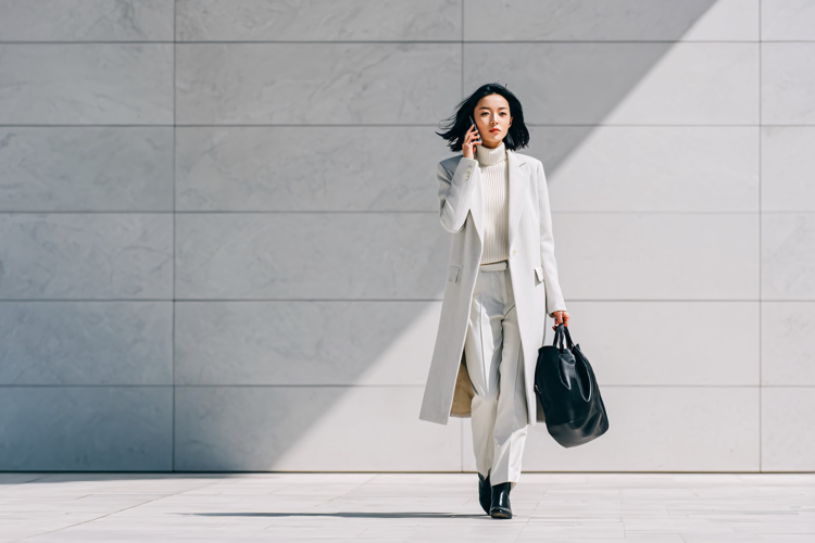 Businesswoman Talking on Phone While Walking Outdoors,
