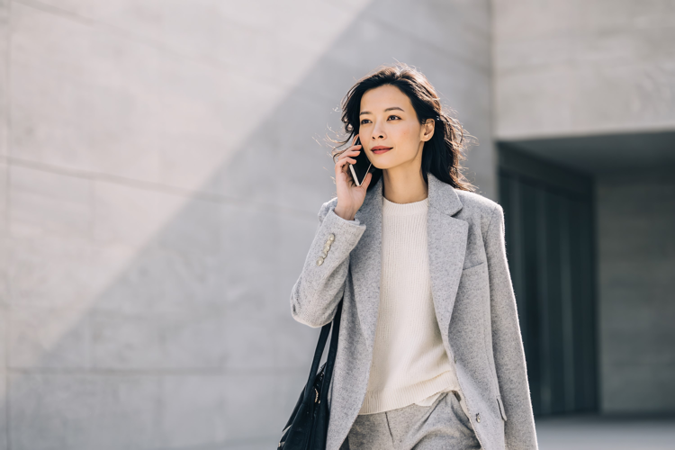 Businesswoman Talking on Phone Outdoors with Modern