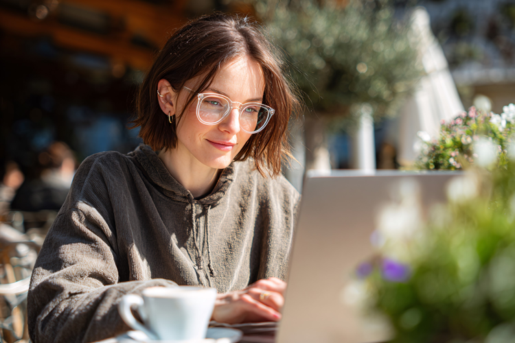 Woman Working on Laptop at Cafe