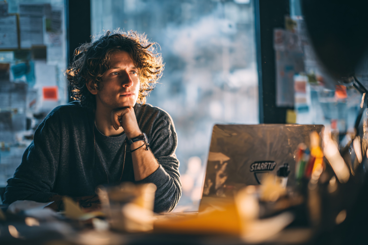 Young Man Thinking at Office Desk