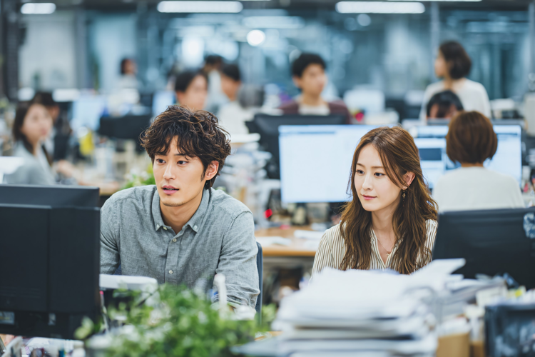 Office workers collaborating, focused on computer screens