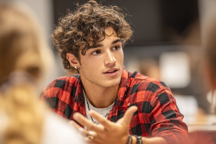 Young Man Gesturing During Discussion example image 1