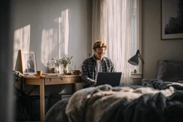 Man Working on Laptop in Cozy Home Office with Natural Light