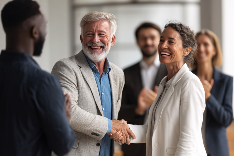Diverse business team shaking hands, celebrating success