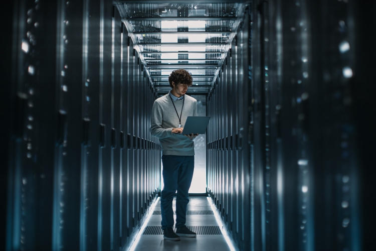 IT Technician Working on Laptop in Modern Data Center Server