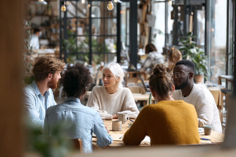 Diverse colleagues collaborating around table in modern