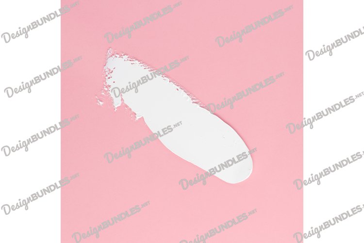 Smear of white cream for face and body on a pink background example image 1