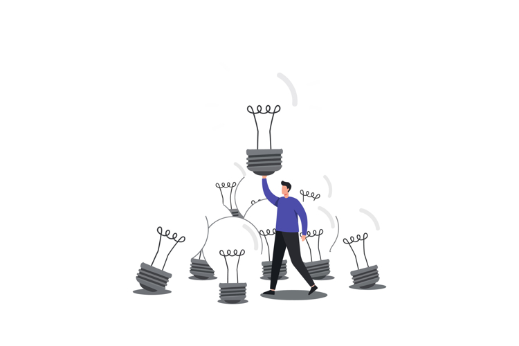 Person lifting light bulb while surrounded by smaller bulbs