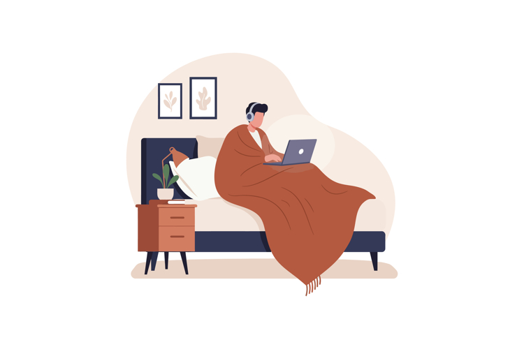 Person working on laptop in bed with headphones and brown bl