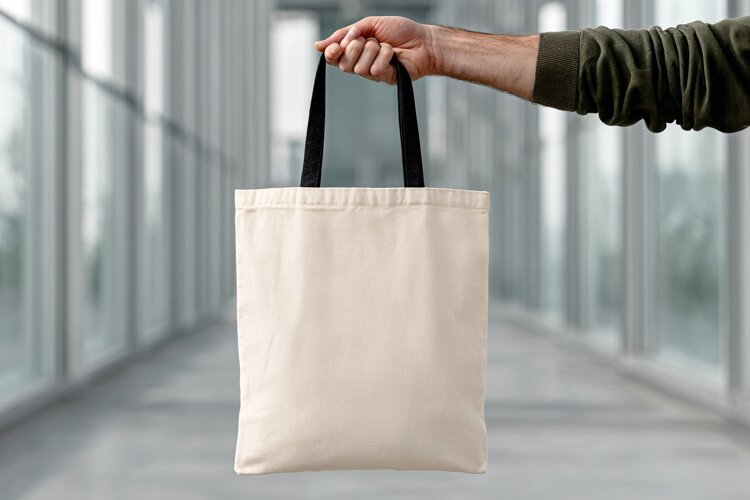Person Holding Canvas Tote Bag Mockup example image 1