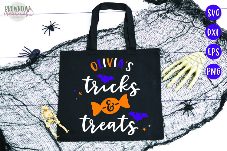 Tricks and Treats quote with an orange piece of candy and bats and stars on a black tote bag for trick or treating